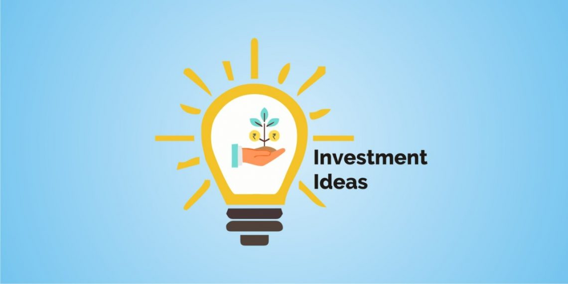 A bright light bulb with a plant growing in a hand inside it, symbolizing investment ideas, against a blue background. Rays of light emanate from the glowing bulb, indicating it is on or shining brightly. To the right of the light bulb, “investment ideas” is written in bold black letters.