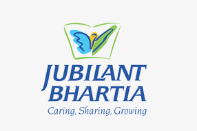 A logo for jubilant bhartia, a company with a blue and green butterfly-like design and the words ‘caring, sharing, growing’.