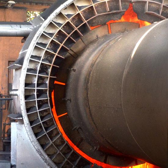 A close up of a large industrial machine with a spiral pattern and glowing orange accents.